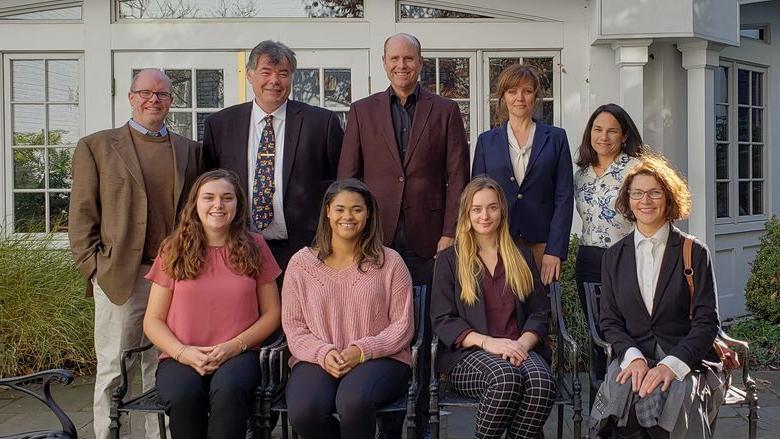 A group of nine faculty, staff, and students in front of the Nittany Lion Inn